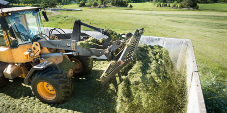 En man i en traktor utför arbete på ett jordbruk.