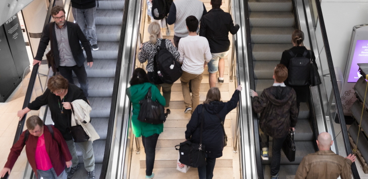 Folk som färdas upp och ner i trappa och rulltrappa