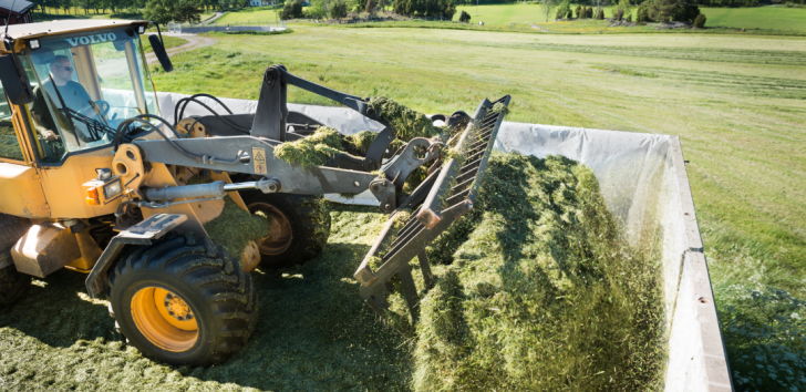 En man i en traktor utför arbete på ett jordbruk.