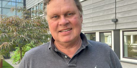 Arbetsmiljöverkets projektledare Magnus Henriksson står utomhus framför en modern byggnad. Han har på sig en grå pikétröja.