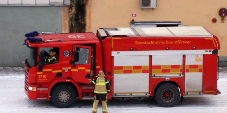 En röd brandbil utanför en brandstation.