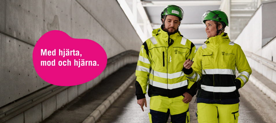 Två personer med hjälmar och arbetskläder och en text "Med hjärta, mod och hjärna"