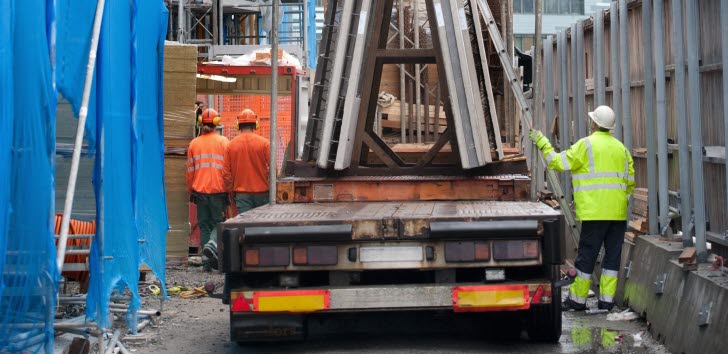 En lastbil med betongblock på en byggarbetsplats.